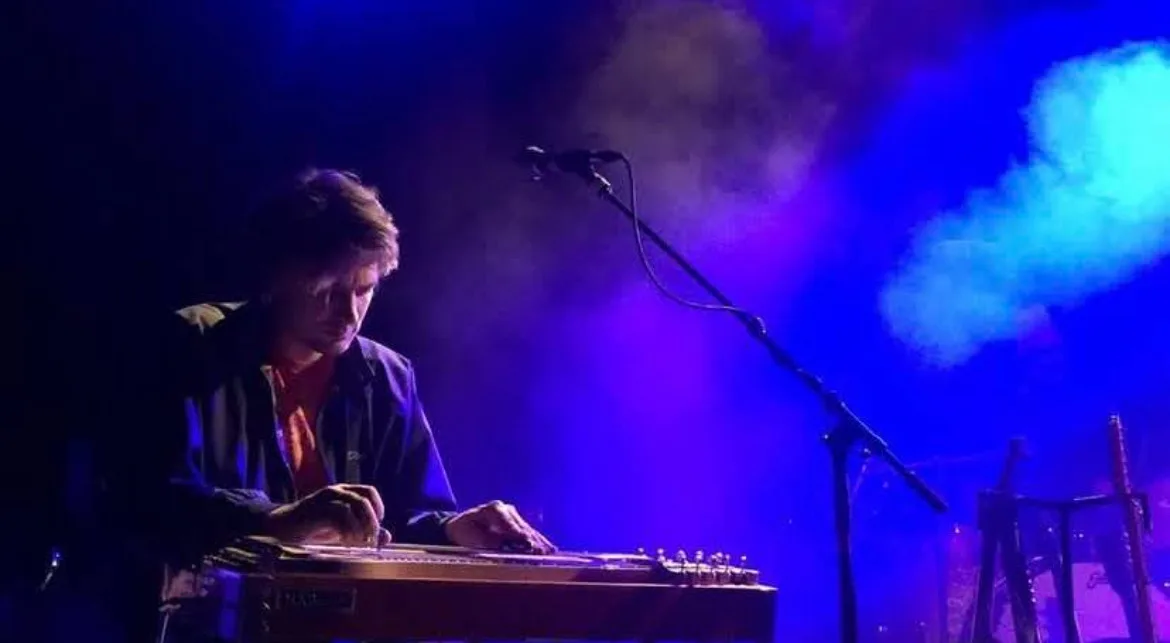 Brett Lanier playing pedal steel under blue stage lights