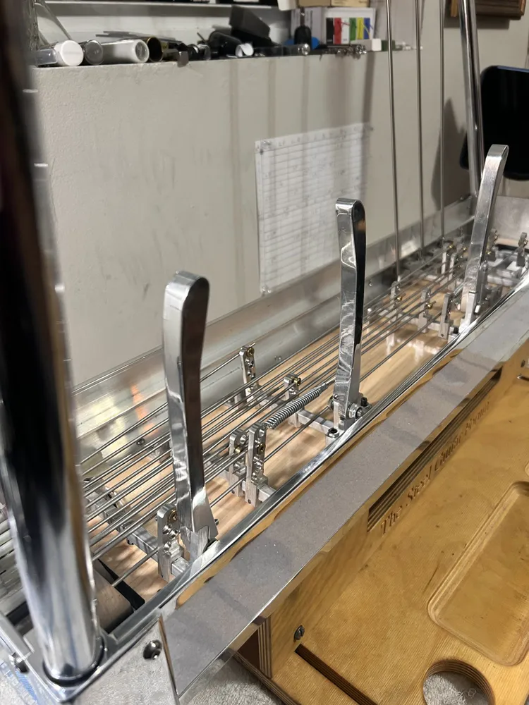 Knee levers and pull rods on a pedal steel turned over on the bench