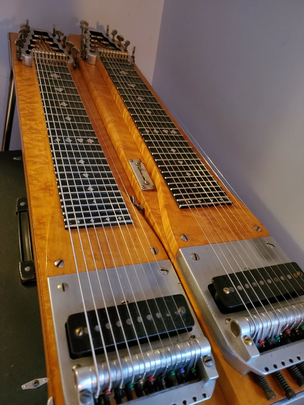 A birdseye-maple double-neck pedal steel, its pickups and changer up close